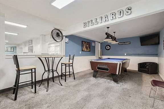 a game room with a pool table and a bar