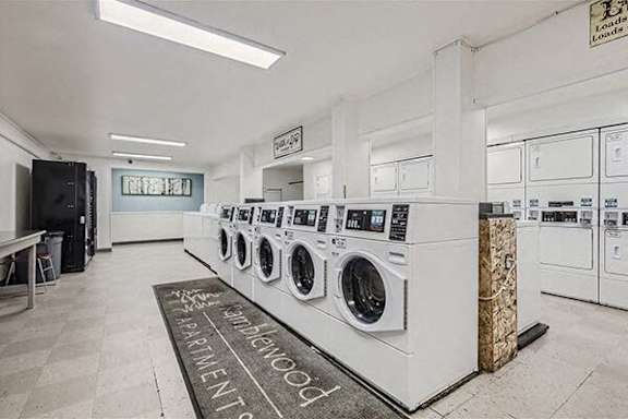 a laundry room with a row of washing machines