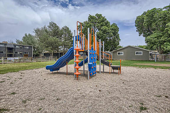 a playground with slides and chairs in a park