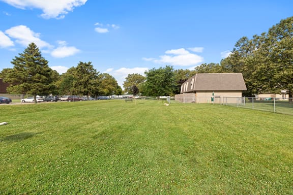 a large field of grass with a building in the background