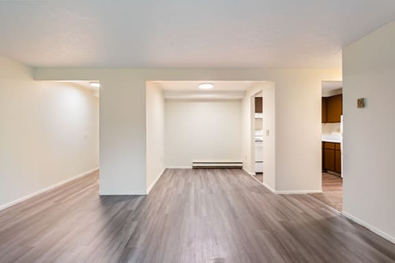 an empty living room with white walls and wood flooring