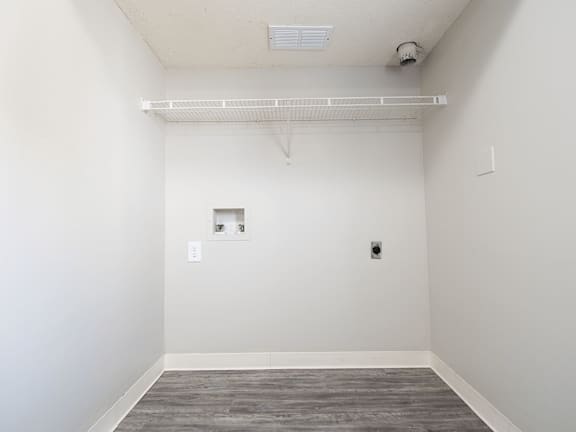 A room with a white wall and a grey floor.