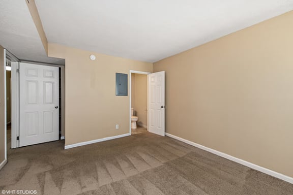 an empty living room with a door to a bathroom