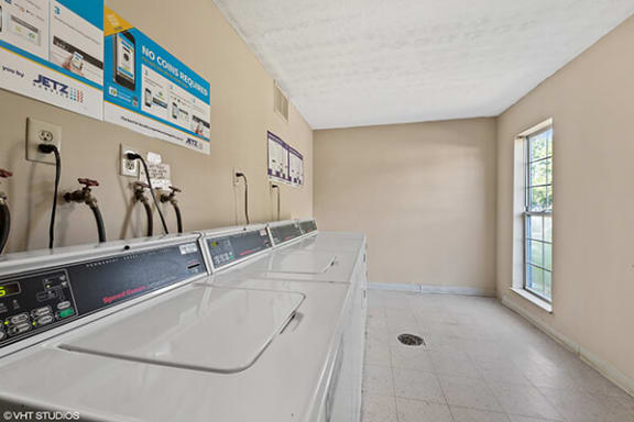 a laundry room with several sinks and a window