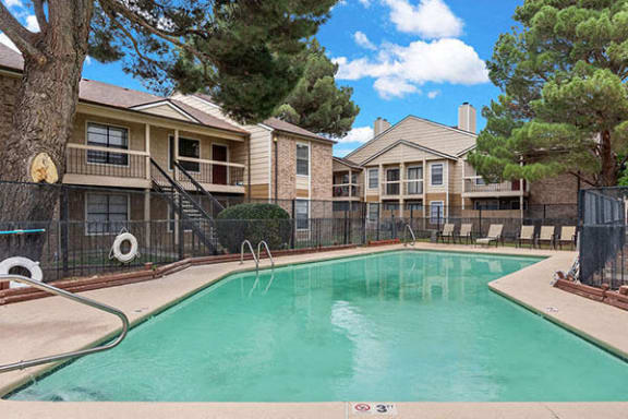 a swimming pool with apartments in the background at saddlecreek