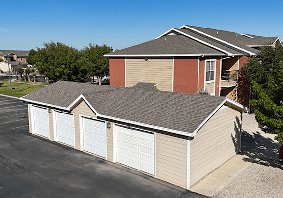 A house with a brown roof and a garage with white doors.