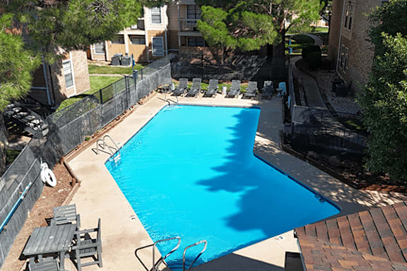 A blue swimming pool surrounded by a black fence.