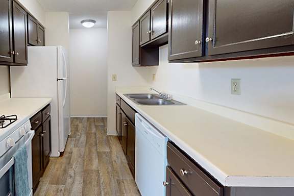 A kitchen with a white refrigerator and wooden floors.