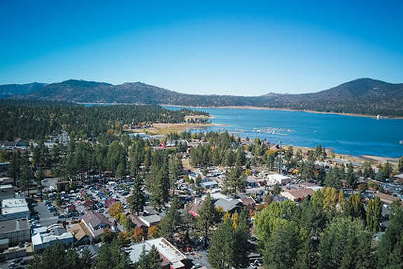 A small town with a beach and mountains in the background.