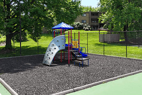 A playground with a blue and yellow slide.