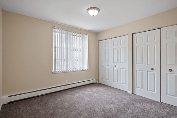 a bedroom with two closets and a window