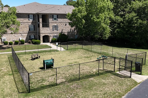 A playground with a green slide and a fence.