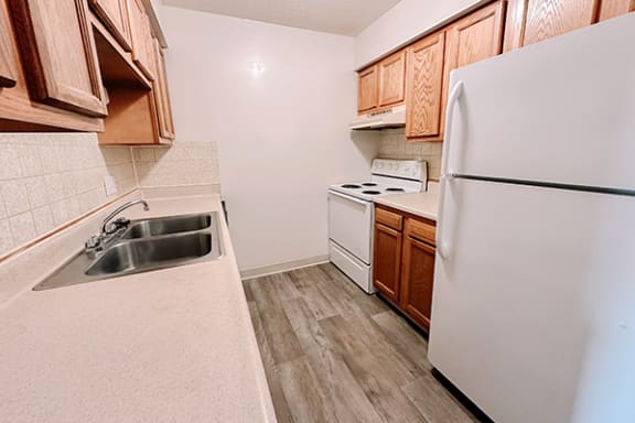 a kitchen with white appliances and wooden cabinets