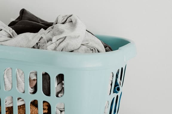 a blue laundry basket filled with clothes