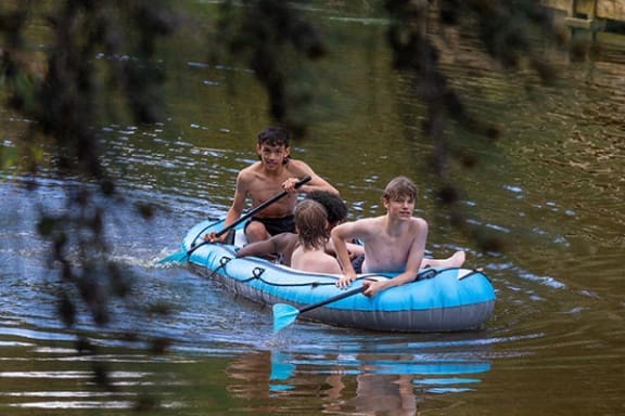 a group of people in an inflatable raft on a river