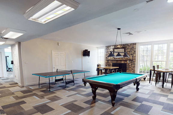 A room with a pool table and a fireplace.