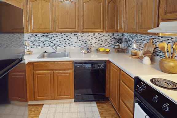 A kitchen with wooden cabinets and a black oven.
