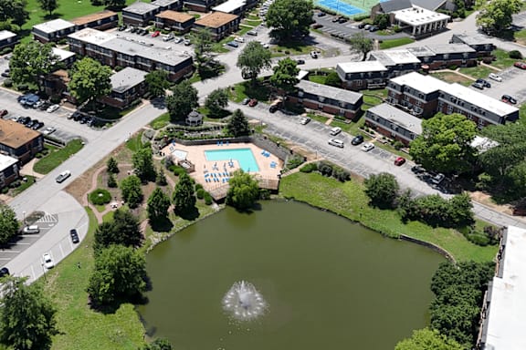 An aerial view of a community with a pond and a pool.
