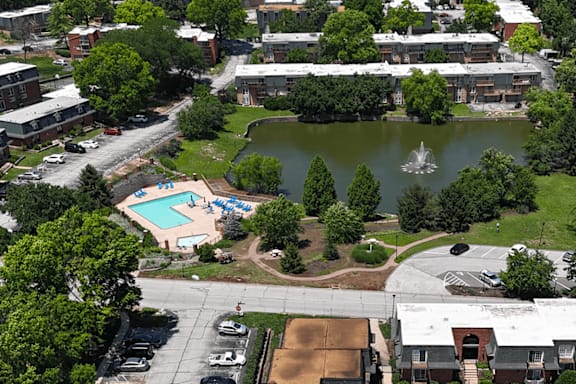 A view of a community with a pool and a pond.