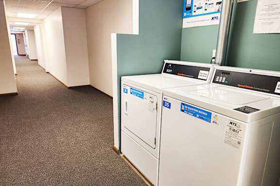 A white washing machine is in a hallway.