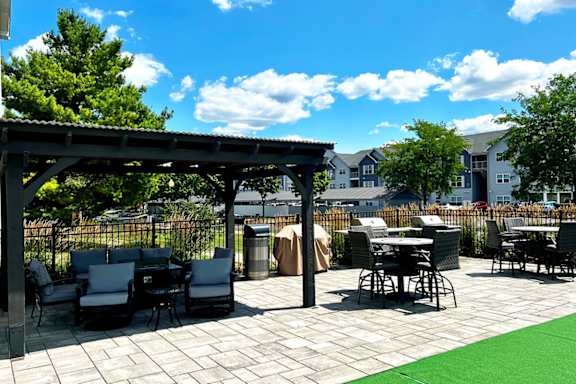 A patio with a table and chairs under a roof.
