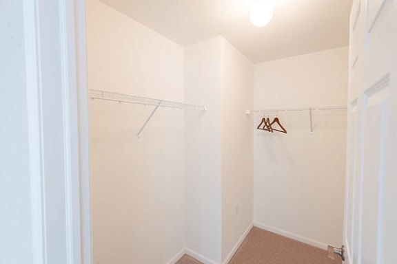 a closet with a white wall and a hanging rack