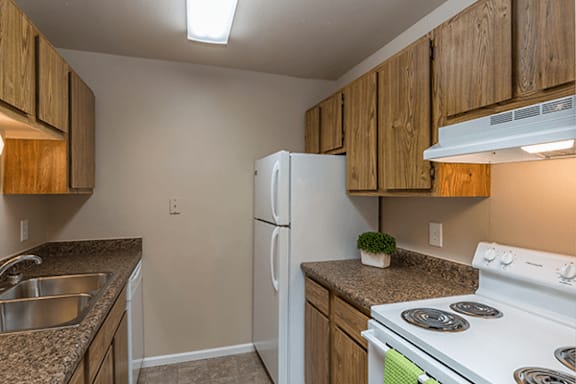 A kitchen with a white stove and wooden cabinets.