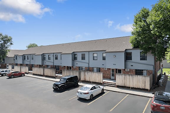 A parking lot with cars and a building in the background.