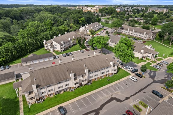 an aerial view of an apartment complex with cars parked in a parking lot