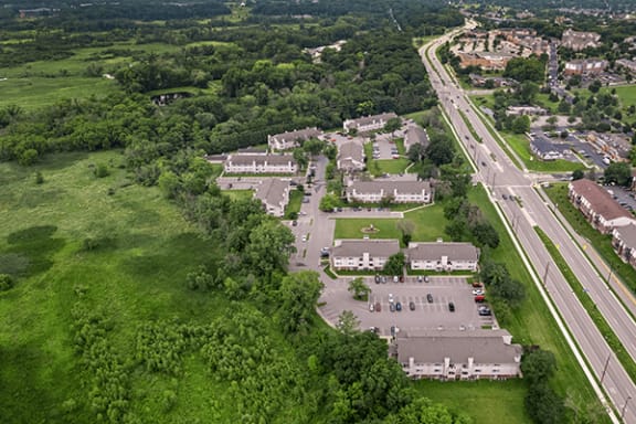 an aerial view of a city with cars parked in a parking lot