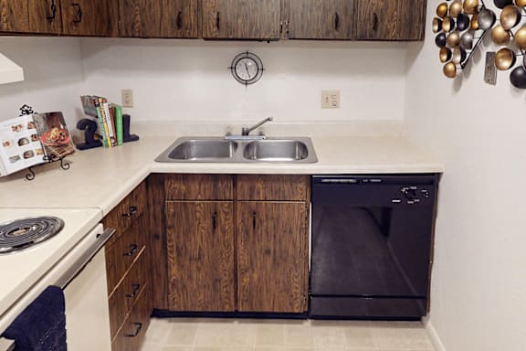 A kitchen with a black oven and wooden cabinets.