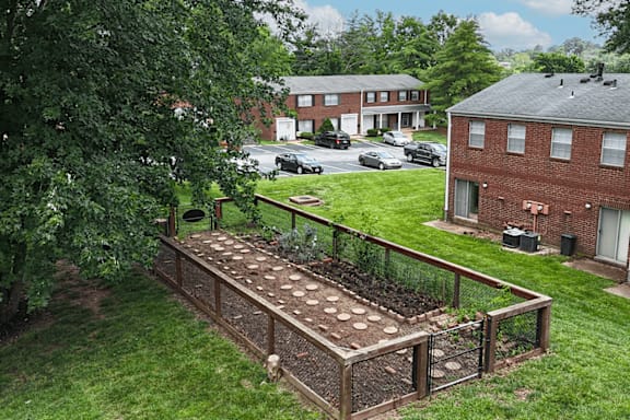 A garden with a fence and a green lawn.