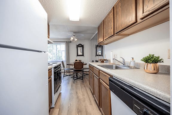 A kitchen with a white refrigerator and wooden cabinets.