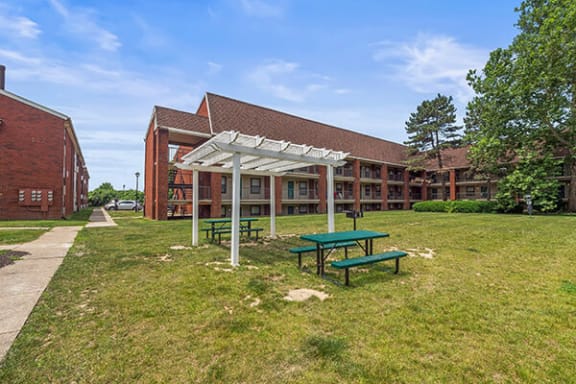 a picnic area in the grass in front of a building