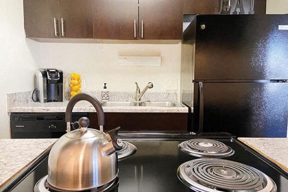a kitchen with a stove with a tea kettle on it
