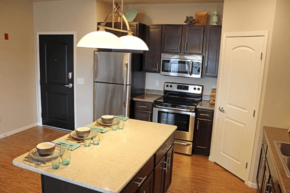 a kitchen with a large island and stainless steel appliances