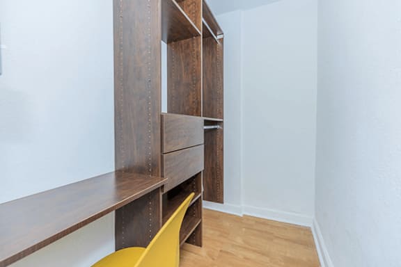 a room with a yellow chair and a closet with shelves