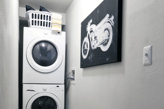a white washer and dryer in a room with a painting of a motorcycle