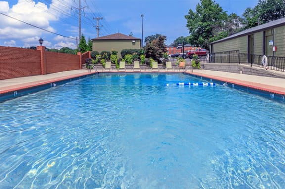 a large swimming pool is next to a house