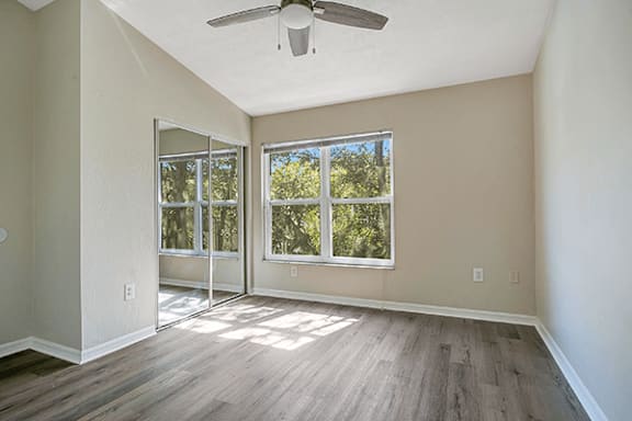 A room with a ceiling fan and sliding glass doors.