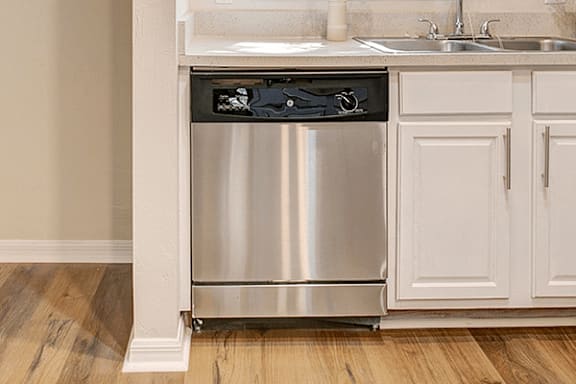 A stainless steel dishwasher is built into a kitchen counter.