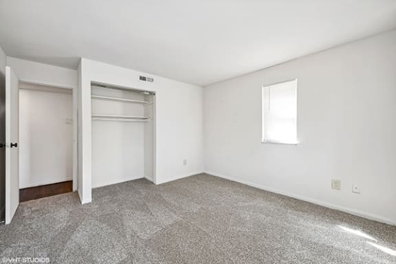 an empty room with white walls and a door to a closet