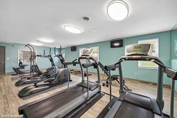A gym with treadmills and elliptical machines.