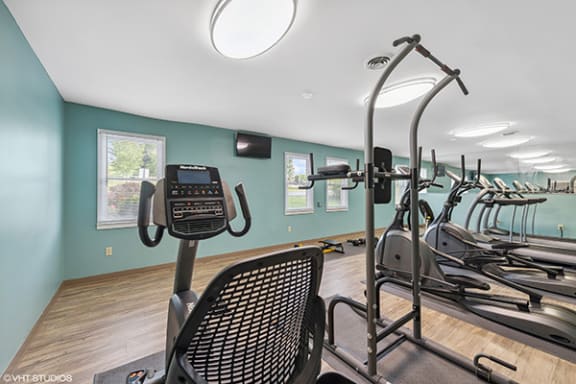 a gym with various exercise equipment on a row of chairs