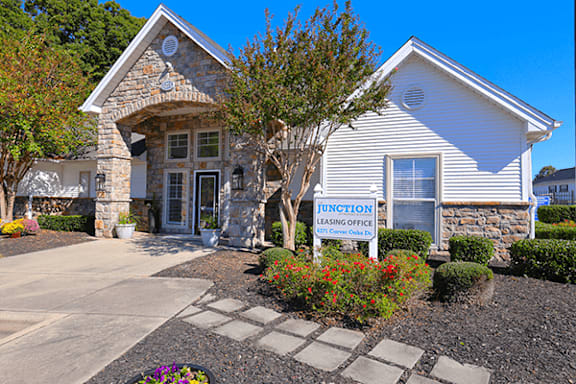 A club house building with a stone pillar and a sign that says "Junction Leasing Office".