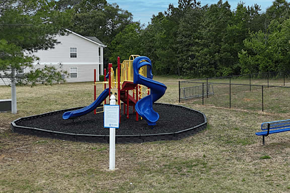 A playground with a blue and yellow slide.