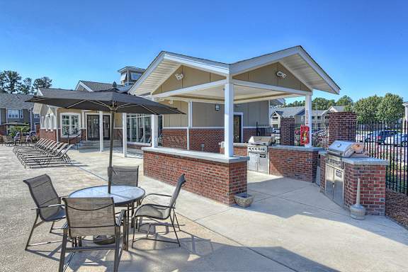 A patio with a table and chairs under a roof.