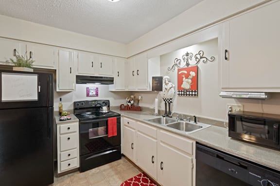 a kitchen with black appliances and white cabinets
