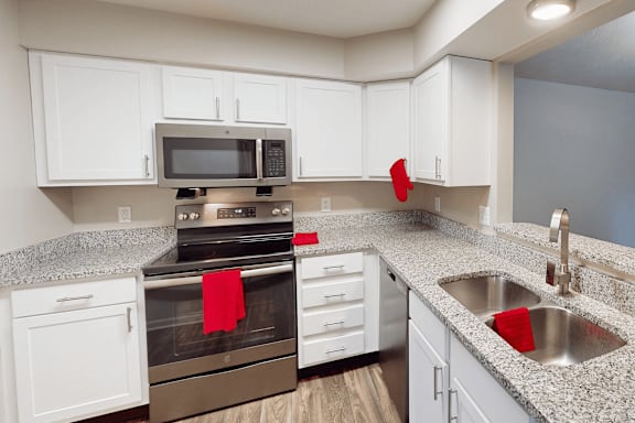 A kitchen with white cabinets and a granite countertop.