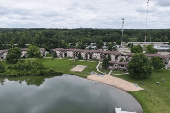 A large building complex with a lake in front.